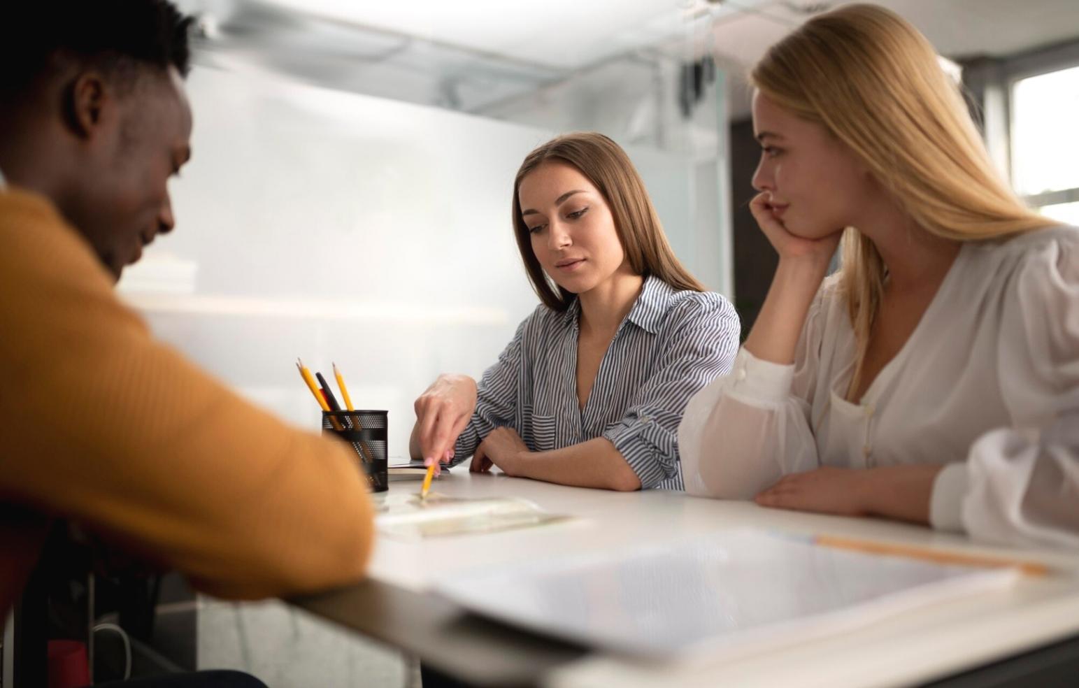 Close-up of hands reviewing detailed budget spreadsheet with handwritten notes